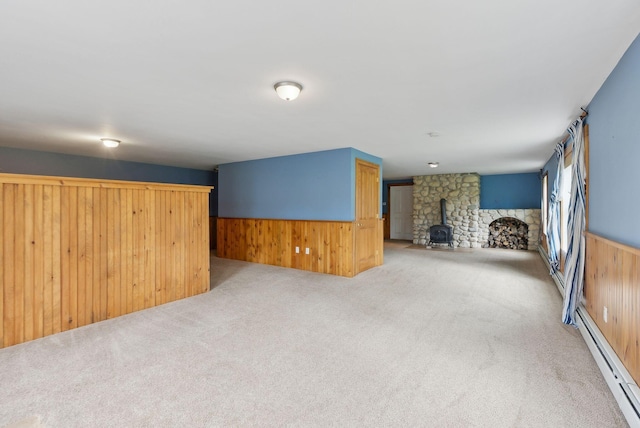 20 Motorcycle Dr, Windham, ME 04062 - unfurnished living room with a wood stove, baseboard heating, wood walls, carpet floors, and wainscoting