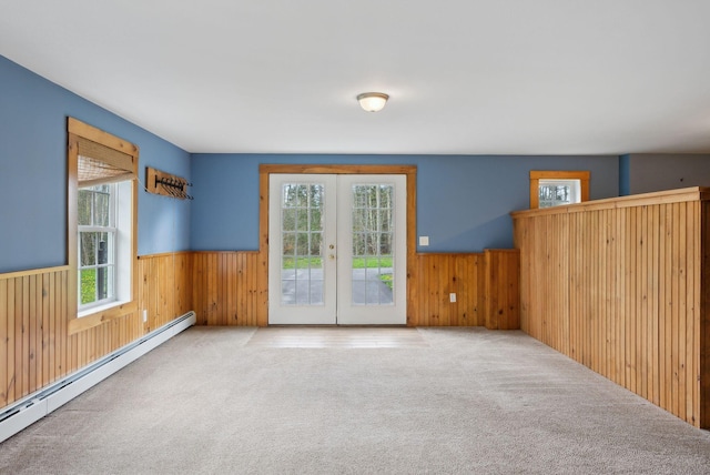 20 Motorcycle Dr, Windham, ME 04062 - empty room with a baseboard heating unit, a wainscoted wall, carpet floors, wood walls, and french doors
