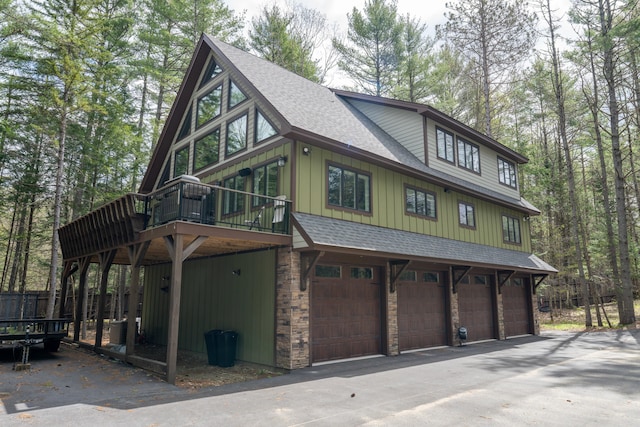 106 Webb River Dr, Dixfield, ME 04224 - view of front of house with a shingled roof, asphalt driveway, an attached garage, and board and batten siding