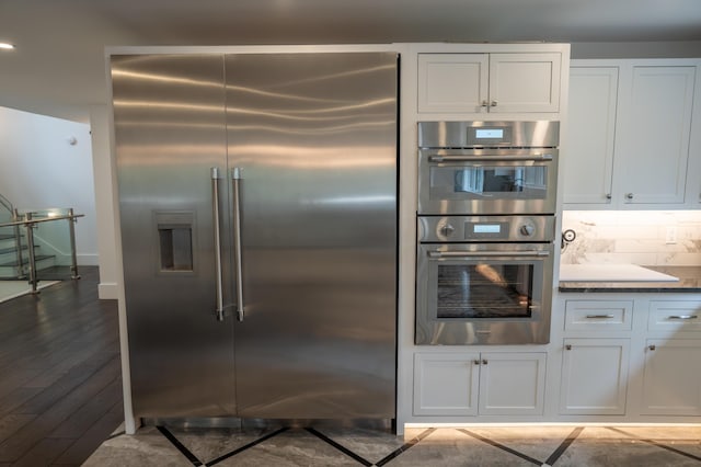 106 Webb River Dr, Dixfield, ME 04224 - kitchen with appliances with stainless steel finishes, white cabinets, dark countertops, backsplash, and baseboards
