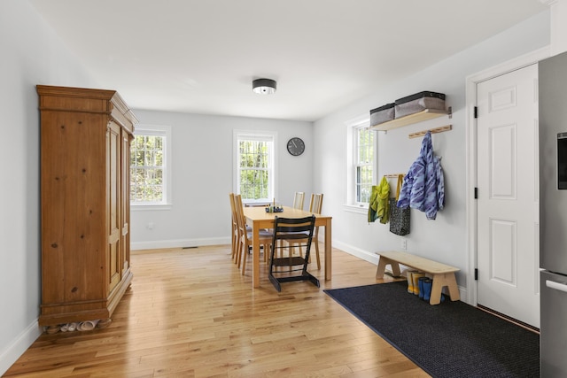 dining area with light wood-type flooring and baseboards