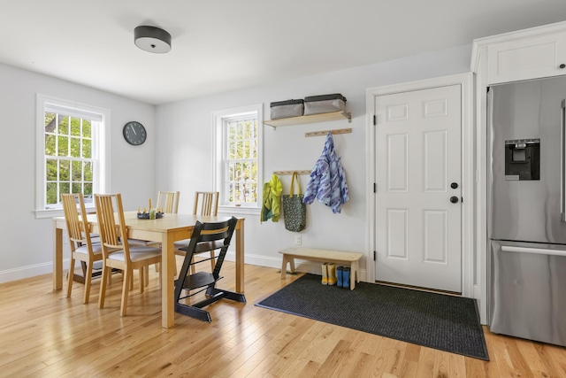 dining space featuring light wood-type flooring and baseboards