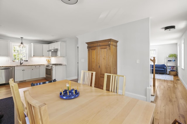 dining area featuring light wood-type flooring and baseboards