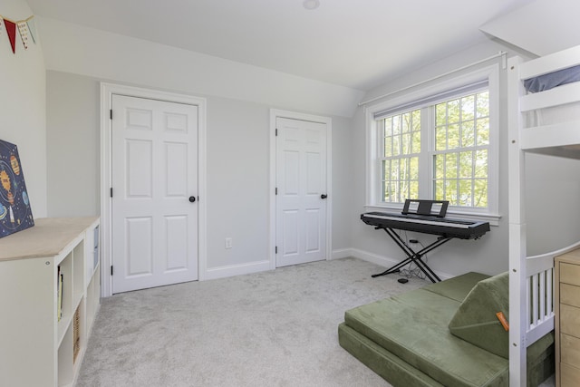 living area featuring carpet floors, vaulted ceiling, and baseboards