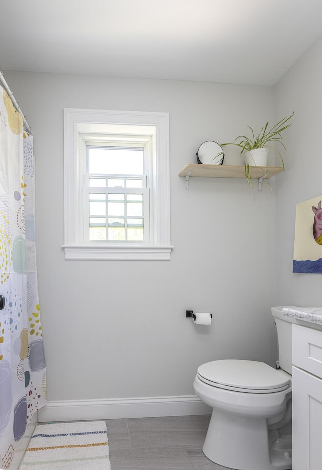 bathroom with baseboards, vanity, toilet, and a shower with shower curtain
