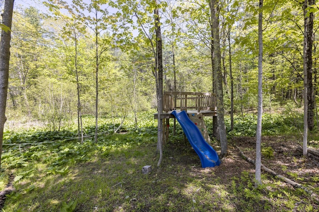 view of playground featuring a wooded view