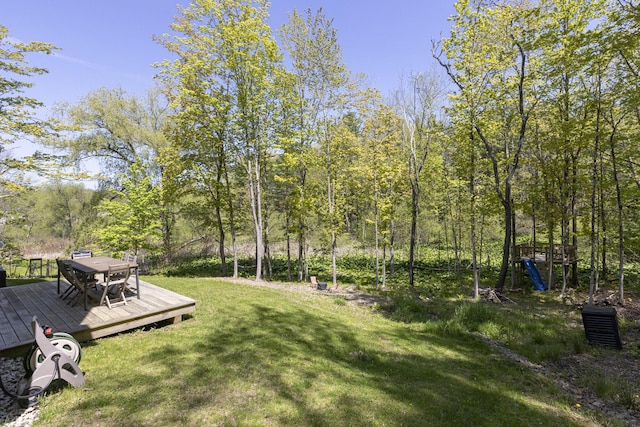 view of grassy yard with a wooden deck