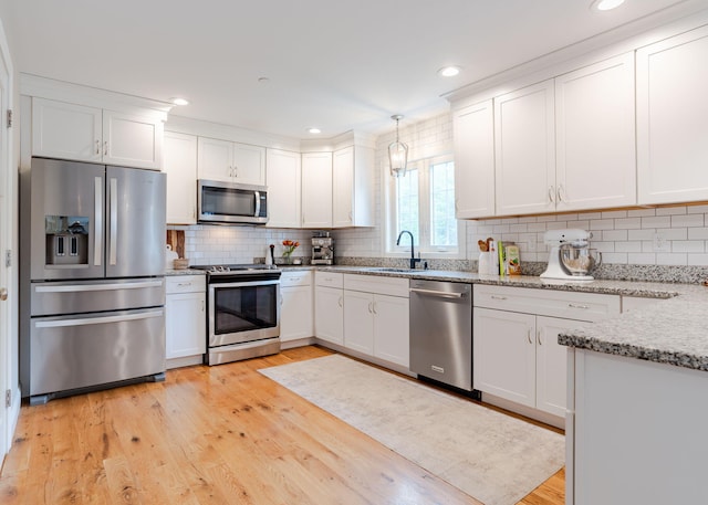 22 Lilac Ln, Gorham, ME 04038 - kitchen featuring appliances with stainless steel finishes, a sink, white cabinetry, tasteful backsplash, and light wood finished floors