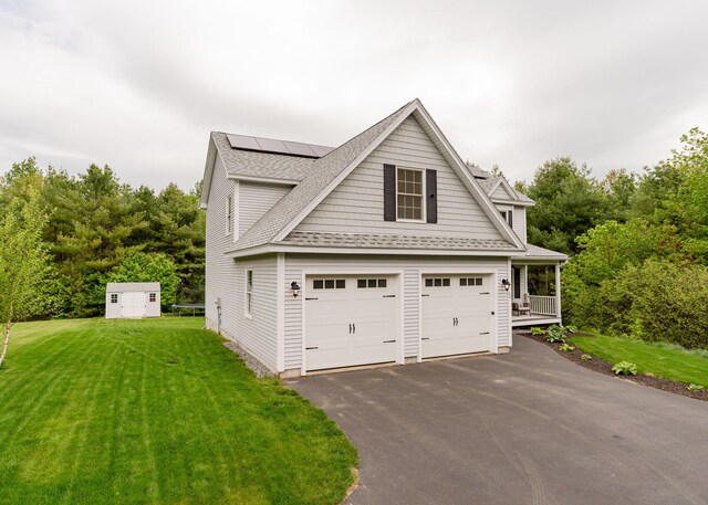 22 Lilac Ln, Gorham, ME 04038 - view of front of house featuring roof mounted solar panels, a front lawn, roof with shingles, a garage, and driveway