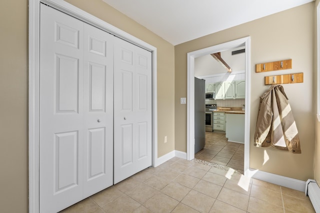 591 Eight Rod Rd, Augusta, ME 04330 - unfurnished bedroom with light tile patterned floors, a closet, baseboards, and a baseboard radiator