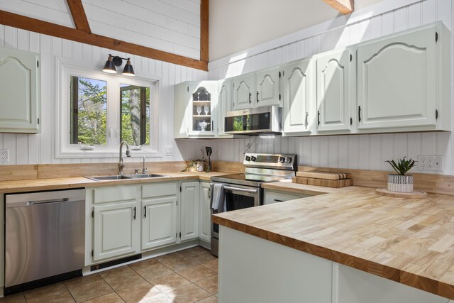591 Eight Rod Rd, Augusta, ME 04330 - kitchen with stainless steel appliances, wooden counters, a sink, light tile patterned floors, and wooden walls