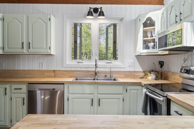 591 Eight Rod Rd, Augusta, ME 04330 - kitchen with wood counters, stainless steel appliances, a sink, glass insert cabinets, and wooden walls