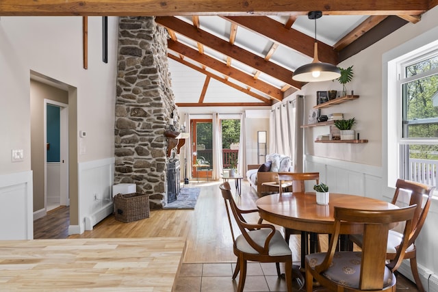 591 Eight Rod Rd, Augusta, ME 04330 - dining area featuring beamed ceiling, plenty of natural light, wainscoting, a high ceiling, and a fireplace