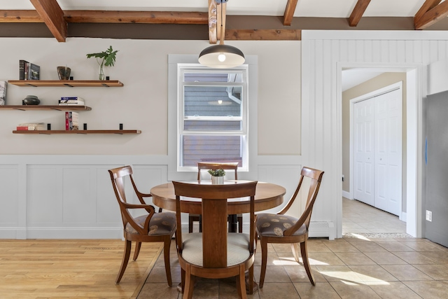 591 Eight Rod Rd, Augusta, ME 04330 - dining space featuring a decorative wall, beamed ceiling, a wainscoted wall, and light tile patterned flooring
