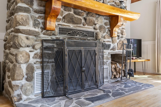 591 Eight Rod Rd, Augusta, ME 04330 - detailed view of wood finished floors, wainscoting, and a fireplace with raised hearth
