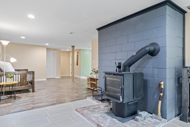591 Eight Rod Rd, Augusta, ME 04330 - living room featuring a wood stove, recessed lighting, concrete block wall, wood finished floors, and baseboards