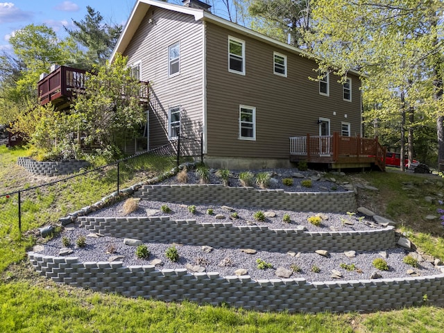 591 Eight Rod Rd, Augusta, ME 04330 - rear view of house featuring fence, a wooden deck, and a chimney