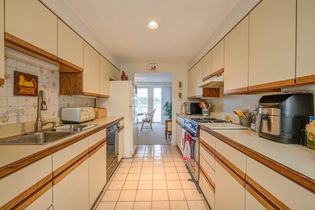 5 Goodridge Dr Unit 5, Naples, ME 04055 - kitchen with under cabinet range hood, a sink, stainless steel appliances, decorative backsplash, and light countertops