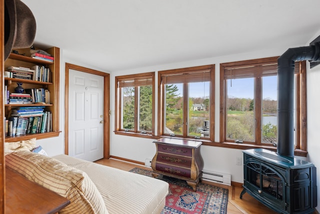 15 Christensen Ln Unit A1, Kennebunk, ME 04043 - bedroom featuring a wood stove, multiple windows, baseboards, and baseboard heating