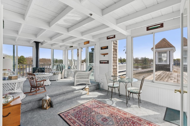15 Christensen Ln Unit A1, Kennebunk, ME 04043 - sunroom / solarium featuring a wood stove, carpet, beam ceiling, and a water view