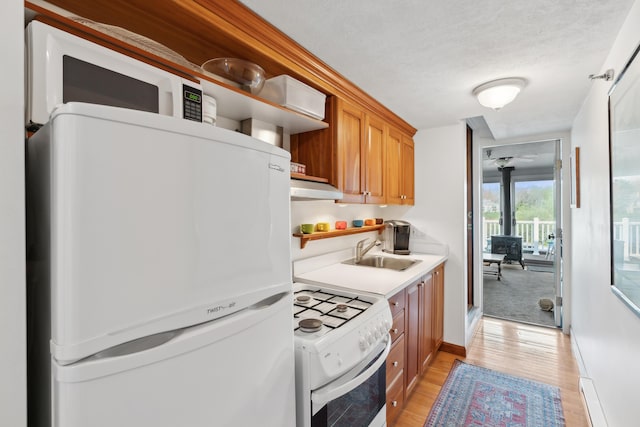 15 Christensen Ln Unit A1, Kennebunk, ME 04043 - kitchen with white appliances, a sink, light countertops, light wood-style flooring, and under cabinet range hood
