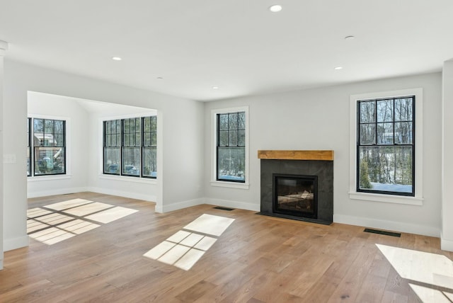 11 Acorn Ave, Kennebunkport, ME 04046 - unfurnished living room with light wood finished floors, a fireplace with flush hearth, baseboards, and recessed lighting