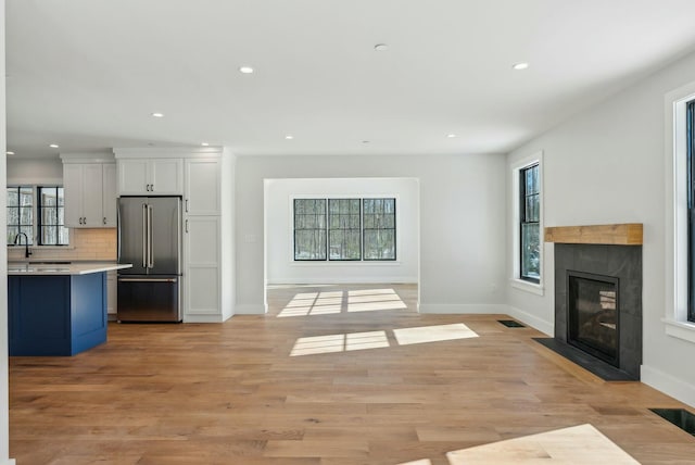 11 Acorn Ave, Kennebunkport, ME 04046 - unfurnished living room with recessed lighting, a fireplace with flush hearth, baseboards, and light wood-type flooring