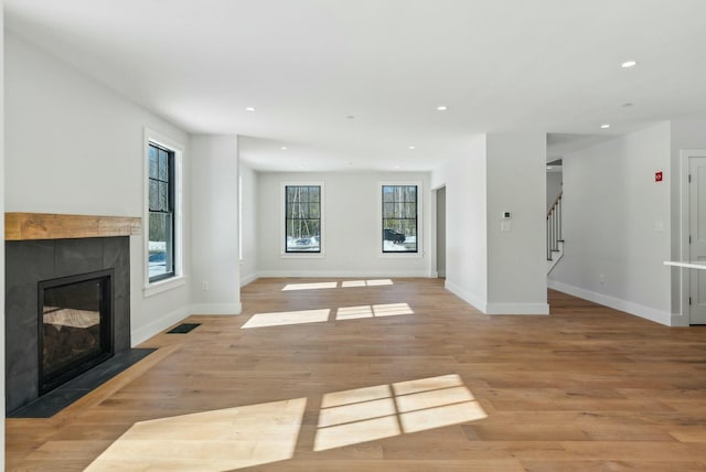 11 Acorn Ave, Kennebunkport, ME 04046 - unfurnished living room featuring a tiled fireplace, baseboards, light wood-style flooring, recessed lighting, and stairs