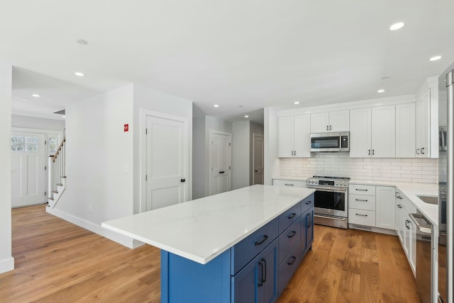 11 Acorn Ave, Kennebunkport, ME 04046 - kitchen with appliances with stainless steel finishes, blue cabinetry, light wood-style floors, light countertops, and recessed lighting