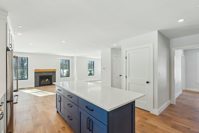 11 Acorn Ave, Kennebunkport, ME 04046 - kitchen featuring light wood-type flooring, freestanding refrigerator, baseboards, a fireplace, and recessed lighting