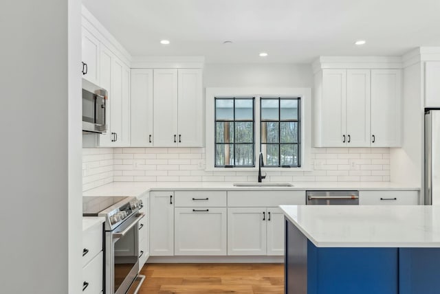11 Acorn Ave, Kennebunkport, ME 04046 - kitchen with stainless steel appliances, a sink, light countertops, white cabinets, and recessed lighting