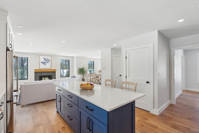 11 Acorn Ave, Kennebunkport, ME 04046 - kitchen with freestanding refrigerator, light wood finished floors, light countertops, a fireplace, and recessed lighting