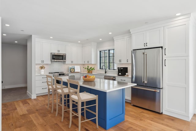 11 Acorn Ave, Kennebunkport, ME 04046 - kitchen featuring appliances with stainless steel finishes, a breakfast bar area, white cabinets, a center island, and recessed lighting