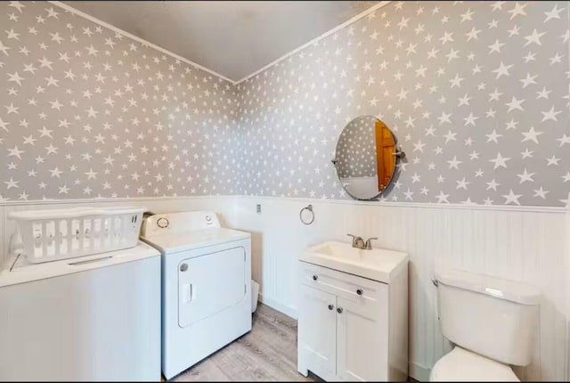 597 Sweden Rd, Bridgton, ME 04009 - laundry area with wallpapered walls, independent washer and dryer, a wainscoted wall, light wood finished floors, and crown molding