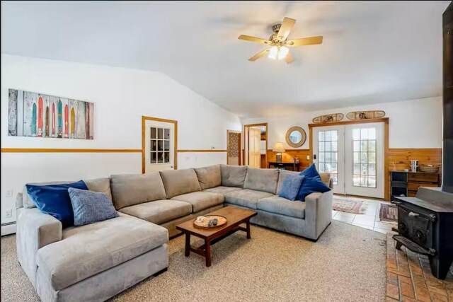 597 Sweden Rd, Bridgton, ME 04009 - living area with lofted ceiling, wainscoting, a wood stove, a ceiling fan, and a baseboard radiator