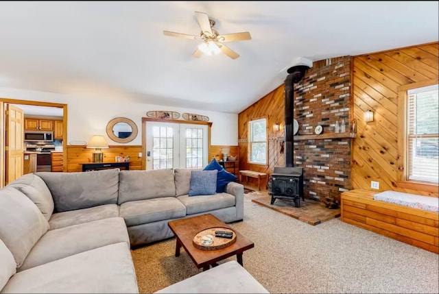597 Sweden Rd, Bridgton, ME 04009 - carpeted living room with wood walls, plenty of natural light, a wood stove, a ceiling fan, and vaulted ceiling