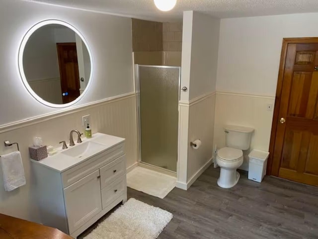 597 Sweden Rd, Bridgton, ME 04009 - full bath featuring wainscoting, a stall shower, wood finished floors, vanity, and toilet