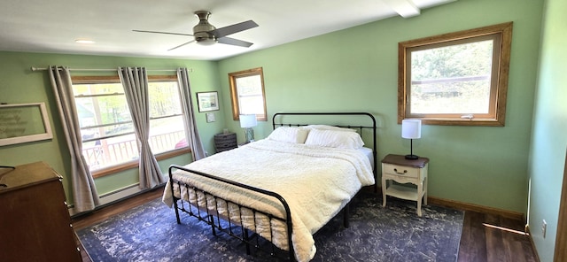 bedroom with multiple windows, wood finished floors, baseboards, and a ceiling fan