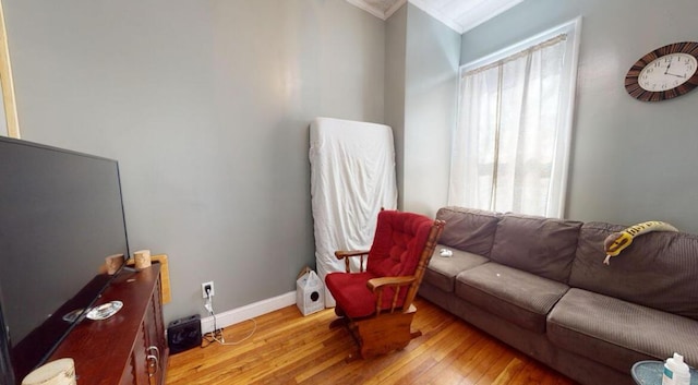 living room with crown molding, hardwood / wood-style flooring, and baseboards