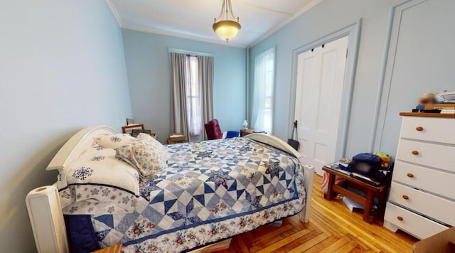 bedroom featuring crown molding and light wood-type flooring