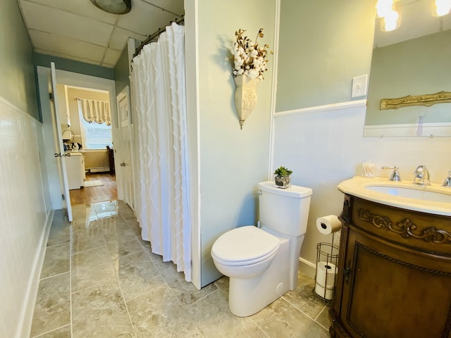 full bathroom with vanity, toilet, wainscoting, and a shower with shower curtain