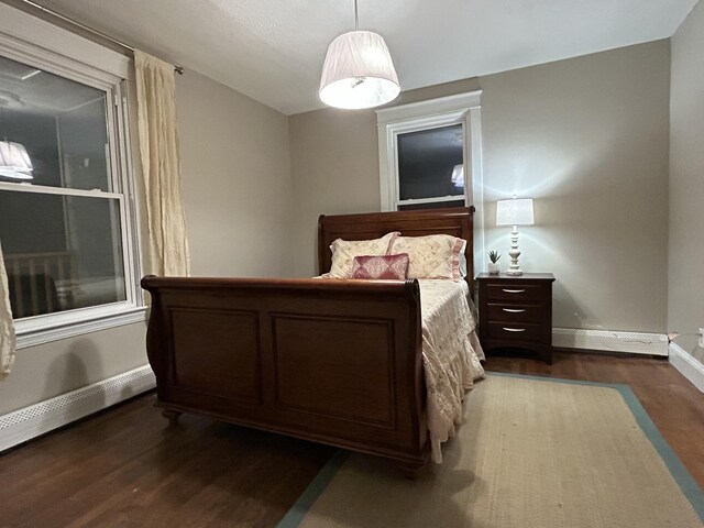 bedroom featuring baseboards and dark wood-style flooring