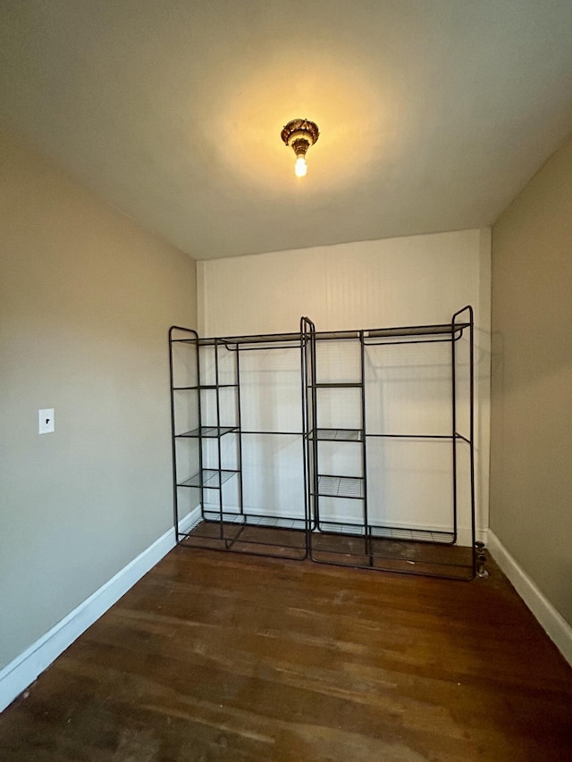 empty room with wood finished floors and baseboards