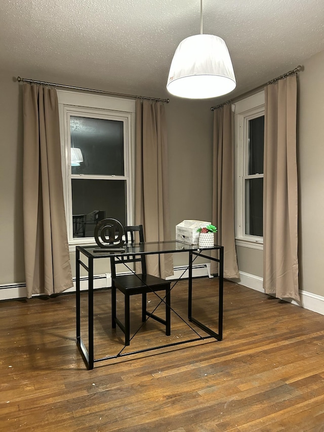 dining room featuring wood finished floors, a textured ceiling, and baseboard heating