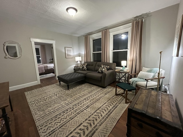 living room featuring a textured ceiling, wood finished floors, and baseboards