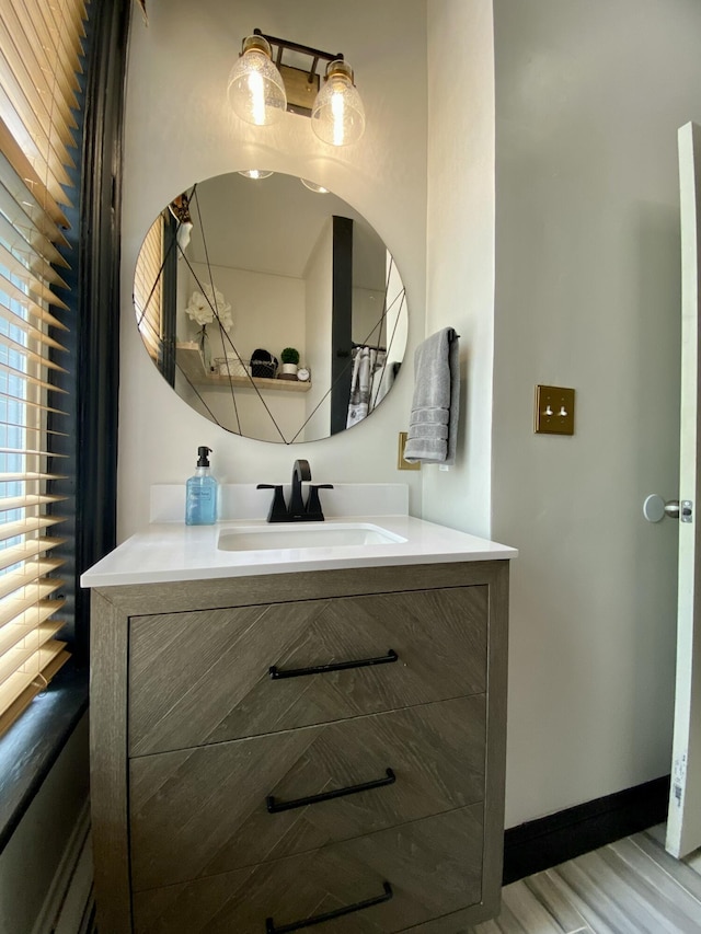 bathroom with wood finished floors, vanity, and baseboards