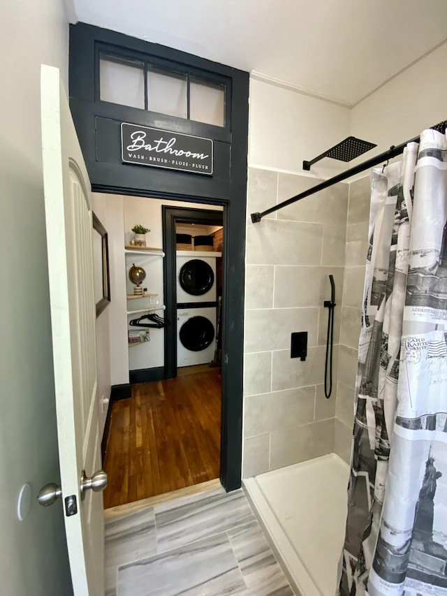 bathroom featuring estacked washer and dryer and tiled shower
