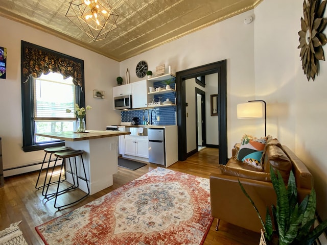 kitchen with stainless steel microwave, refrigerator, an ornate ceiling, white cabinetry, and open shelves