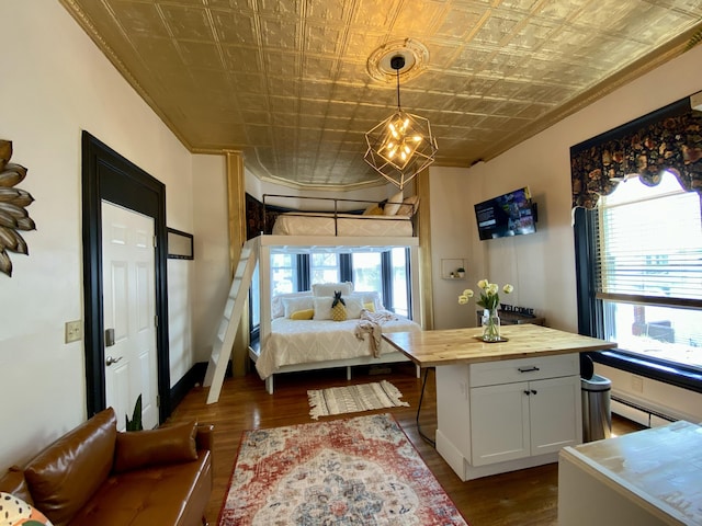 bedroom featuring an ornate ceiling, crown molding, dark wood finished floors, multiple windows, and a baseboard radiator