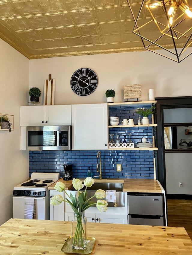 kitchen featuring butcher block counters, stainless steel microwave, white electric stove, an ornate ceiling, and tasteful backsplash